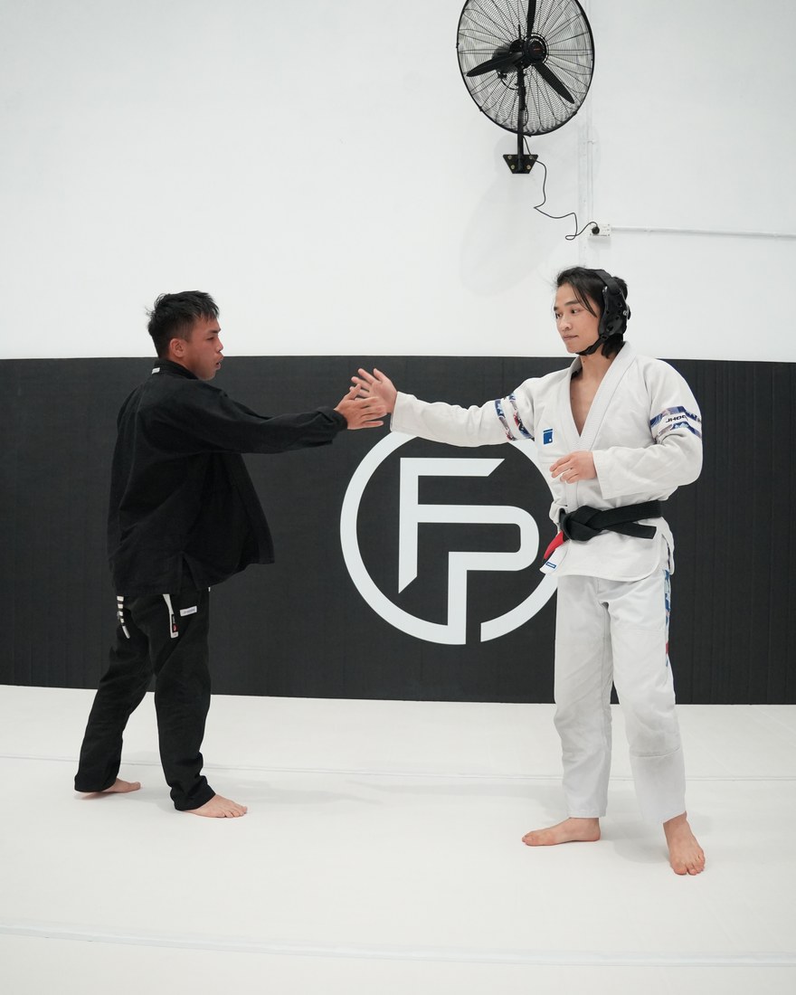 Two training partners slapping hands before starting a round